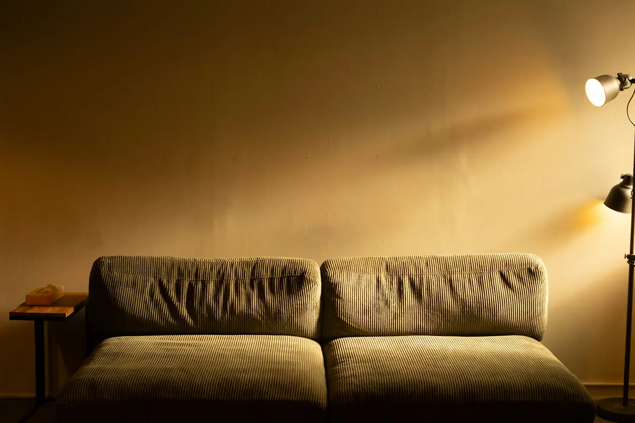 Olive velvet sofa in a warm ochre-lit living room