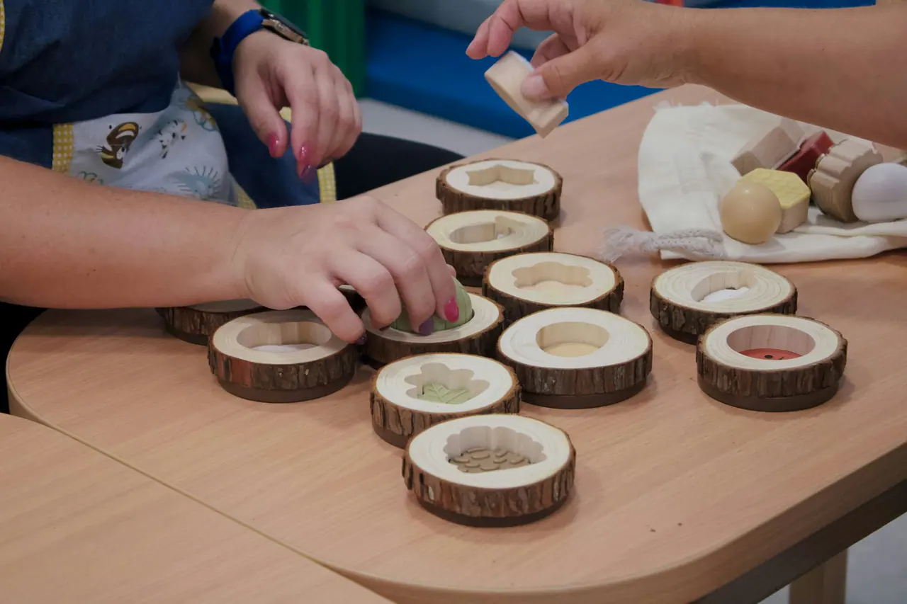 Children's hands arranging wooden discs