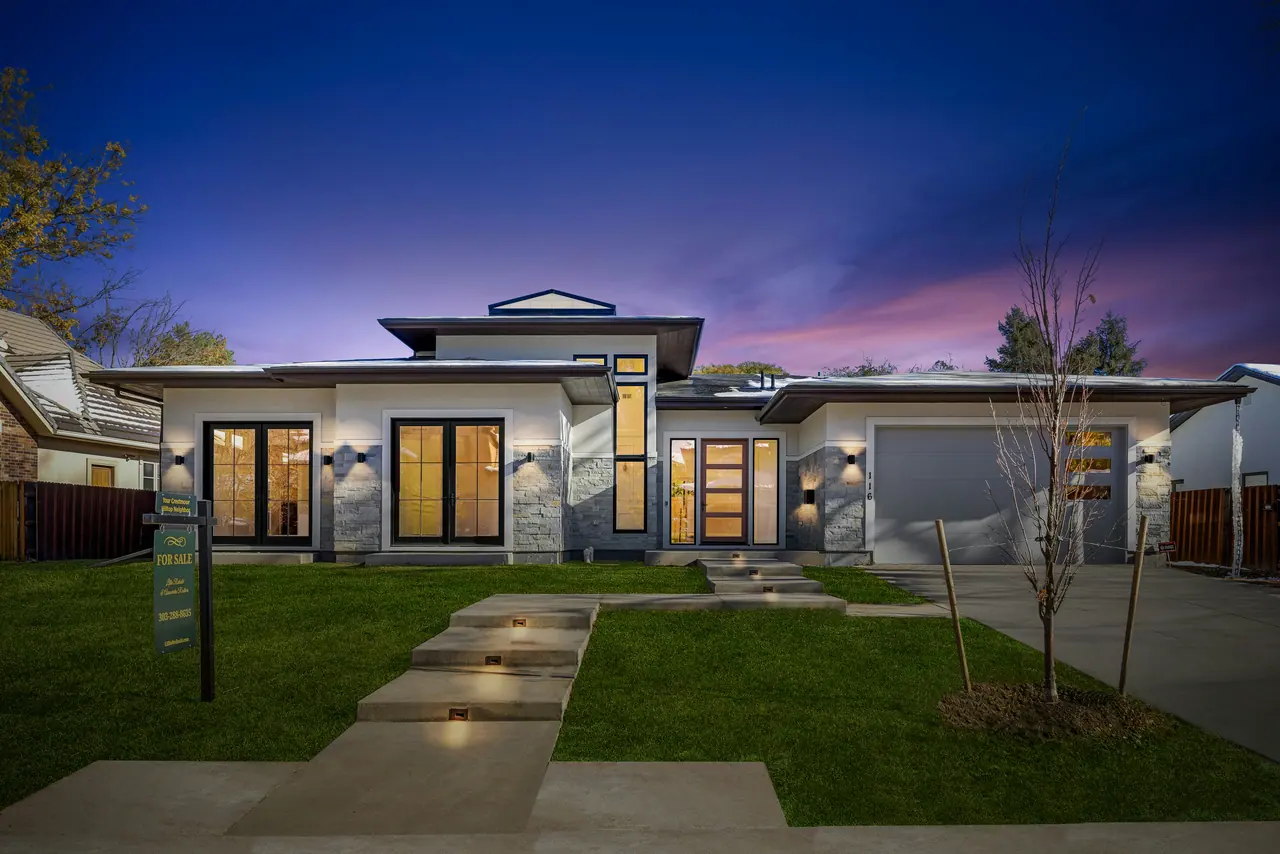 Cantilevered white modern home lit at night