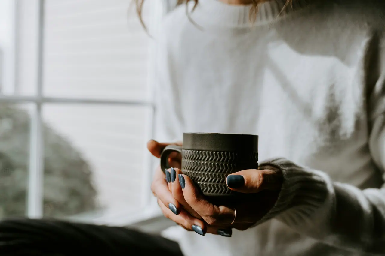 Hands holding a warm ceramic mug